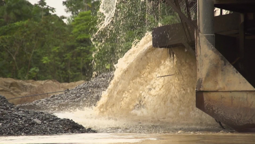 Processed sand and mud spewing out of a gold dredger in to the river in Checo, Colombia. Slow motion. | Shutterstock HD Video #1094976357