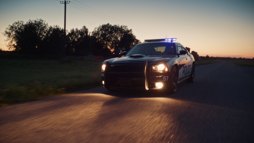 Highway Traffic Patrol Car in Pursuit of Criminal Vehicle, Speeding up the Road. Police Officers Chasing Suspect on Road, Sirens Blazing, Dust Flying. Stylish Cinematic Shot of Energetic Action Scene Royalty-Free Stock Footage #1094977579