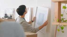 Home and painting for interior design after moving to new building, flat or apartment. Man, couple and art hanging on wall of lounge, happy together to decor in study, living room or office of house - Powered by Shutterstock - Get 15% off with code: PIKWIZARD15
