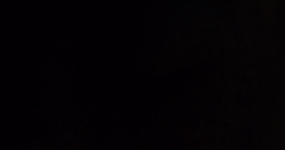 Eyes, art and creative with the eye of a woman opening and her face covered in different color paint. Beauty, artistic and eyes with a female in studio with light fading in and out for effect