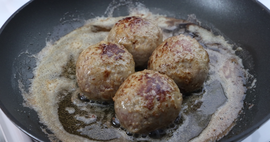 Frying four meatballs in melted butter in a pan, pork meat, gas stove, homemade delicious food. Concept of healthy food in traditional kitchen | Shutterstock HD Video #1094982003