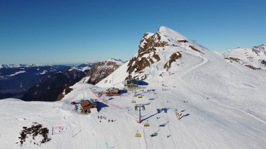 Grindelwald, Switzerland: Aerial drone footage of ski chair lifts in the Jungfrau region ski resort at the Kleine Scheidegg in the Berner Oberland alps near Interlaken on a sunny winter day Royalty-Free Stock Footage #1094982751