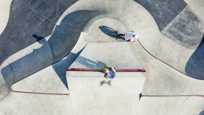 Aerial drone Skate Park concrete bowl shot, large skatepark zone, kick scooter skateboard riders training, skateboarding playground. | Shutterstock HD Video #1094983013