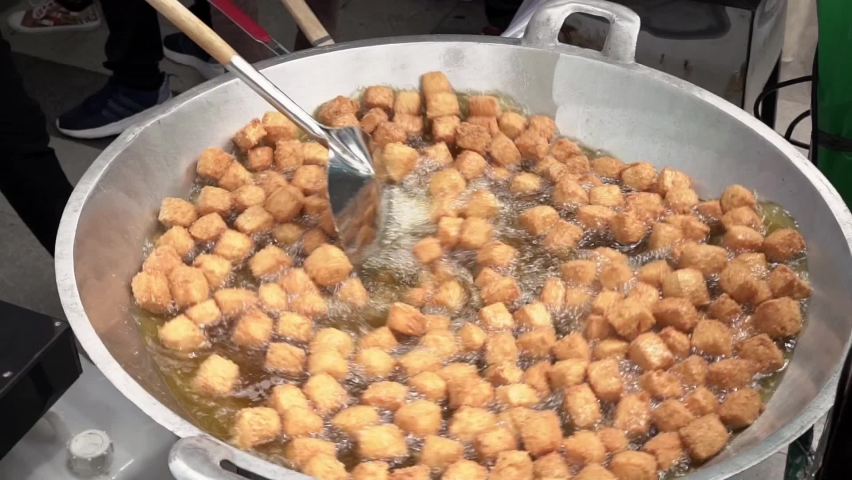 Slow motion of chef is frying tofu in a large skillet. | Shutterstock HD Video #1094985727
