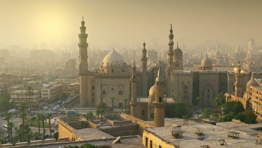 Cairo city in light fog in the rays of setting sun. Zoom out of Mosque of Sultan Hassan, Cairo, Egypt at sunset