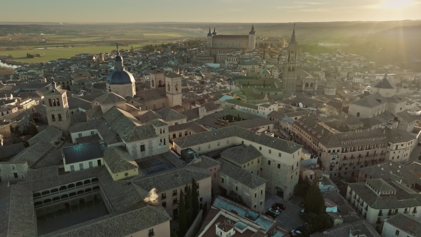 Aerial view of Toledo, Castilla-La Mancha, Spain. Flight over houses and cathedral in Toledo at sunset