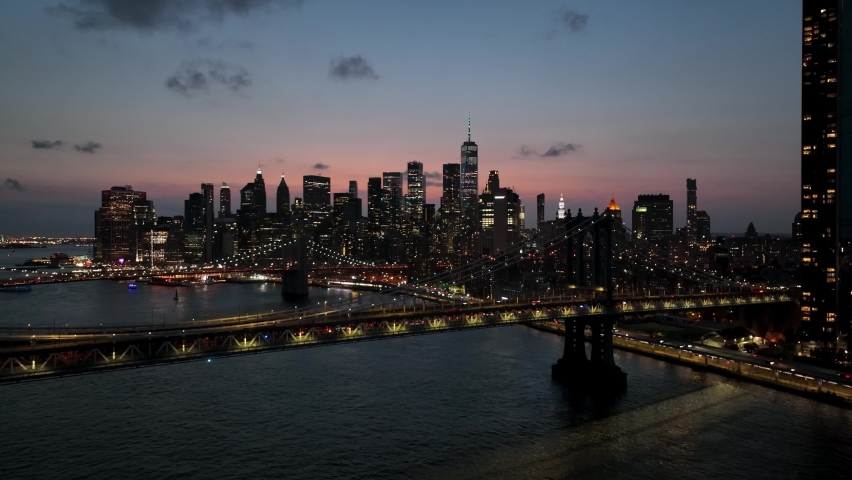 Aerial over East River water Brooklyn Bridge two bridges Manhattan skyline sunset New York City NYC