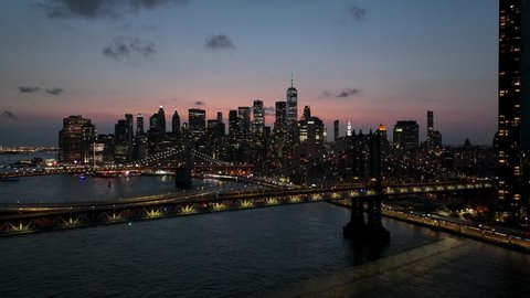 aerial over East River water Brooklyn Bridge two bridges Manhattan skyline sunset New York City NYC Stock Video