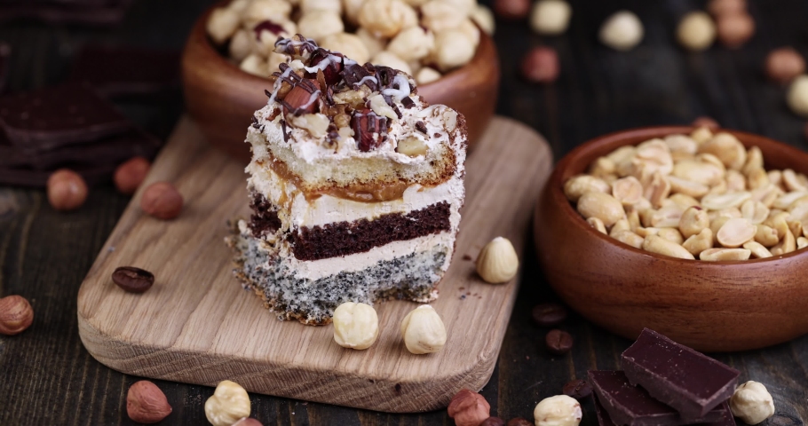 Cut multi-layer cake with different layers, caramel, poppy seeds and cream layers of cake for dessert with nuts | Shutterstock HD Video #1094990949