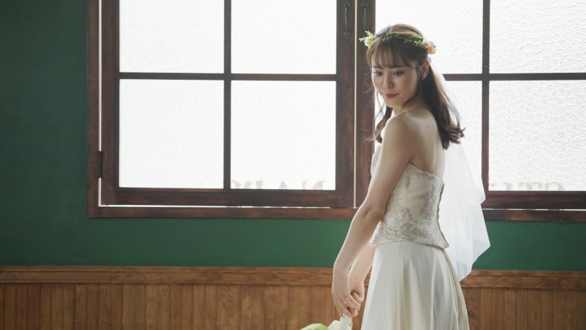 Beautiful young Asian bride in wedding dress