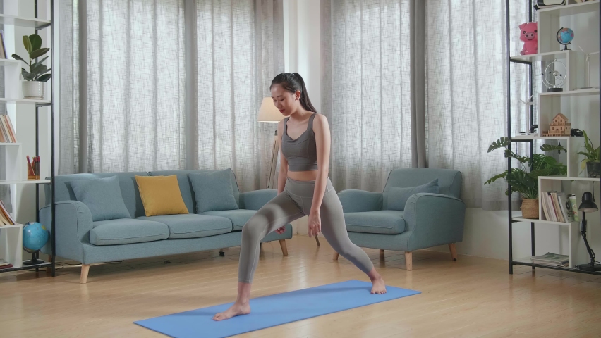 Young Asian Athletic Female Exercising, Stretching And Practicing Yoga At Home. Healthy Lifestyle, Fitness, Wellbeing And Mindfulness Concept
 | Shutterstock HD Video #1094995823