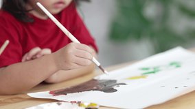 4k video footage of cute little asian baby smiling painting with colorful paints using watercolor. Asian girl using paintbrush drawing color. Baby activity lifestyle concept.