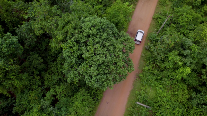 Aerial view of a car in jungle, Off-roading road trip through the forest | Shutterstock HD Video #1095004441