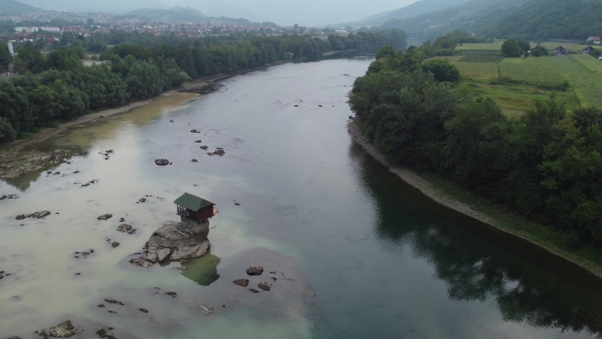 A house on a rock on a river Drina. Lonely house on the Drina river in Bajina Basta, Serbia drone footage. | Shutterstock HD Video #1095004745