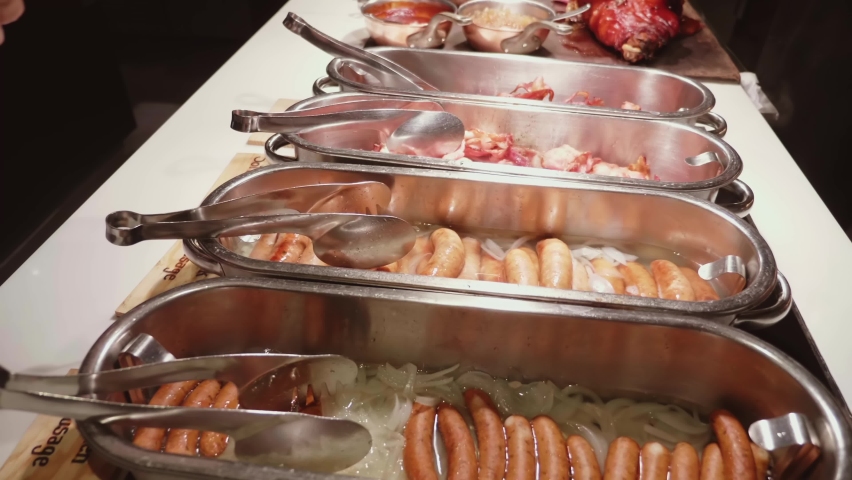 Breakfast buffet in luxury hotel. Big choice of various sausage on buffet table in brunch time in hotel restaurant. Food buffet catering dining | Shutterstock HD Video #1095005341