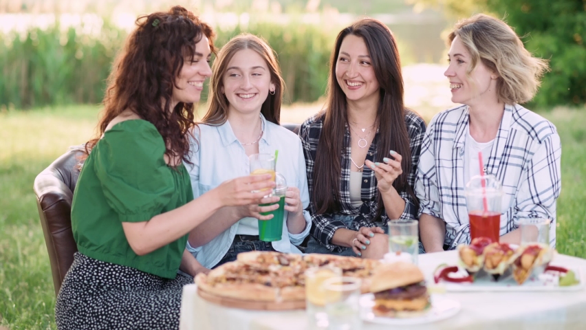 Girlfriends are having fun. Four young cheerful women emotionally speak and laugh outdoors. | Shutterstock HD Video #1095005363