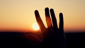Light backdrop. Sunlight sky. Silhouette of palm of hand at sunset close-up. Man stretches his hand to sun silhouette. man's hand in sun close-up. concept of dreams, religion, motivation - Powered by Shutterstock - Get 15% off with code: PIKWIZARD15