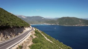 Slow drone footage from a seacoast road near Vasiliki in Lefkada, Greece. Sunny day in Late September