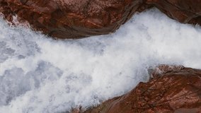 Mountain river. A rapid flow of clean water trapped between rocks. Bubbling water, foam and splashes. Water flow in a mountain gorge, view of the water. natural background. Slow motion video 120 fps.