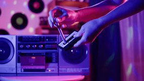 Retro radio tape recorder, putting cassette close-up. Listening to music, old radio boombox player, searching channel or wave. Disco party evening at home. - Powered by Shutterstock - Get 15% off with code: PIKWIZARD15