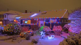Establishing shot of luxury house with nice Christmas decoration at winter snowfall at night in Vancouver, Canada, North America. Night time on December 2021. ProRes 422 HQ. - Powered by Shutterstock - Get 15% off with code: PIKWIZARD15