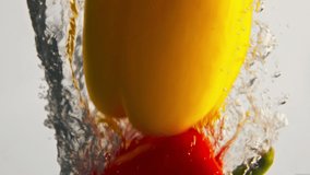 Closeup bell peppers dropping water light background. Fresh organic vegetables splashing washing in bubbling transparent liquid. Seasonal vitamin product. Beautiful natural food commercial shot. - Powered by Shutterstock - Get 15% off with code: PIKWIZARD15