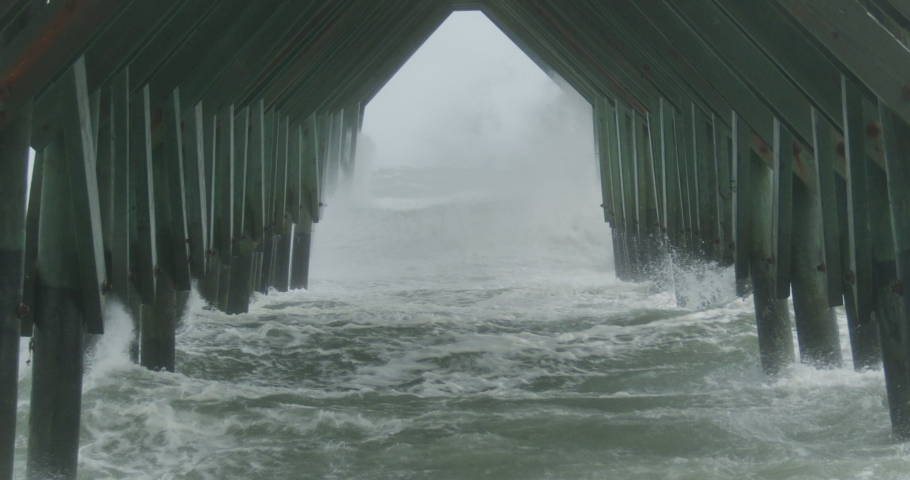 Storm surge from hurricane Ian pounds an ocean pier.
