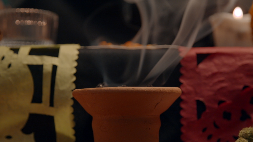 Traditional mexican altar with “papel picado”, copal, incense burner, candles. It helps to clean the space from bad spirits, so the soul of the beloved can come back.
Smoke in Slow motion. Close Up  Royalty-Free Stock Footage #1095019541