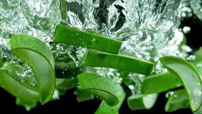 Super slow motion of falling aloe vera into water. Isolated on black background. Filmed on high speed cinema camera, 1000fps. Speed ramp effect.