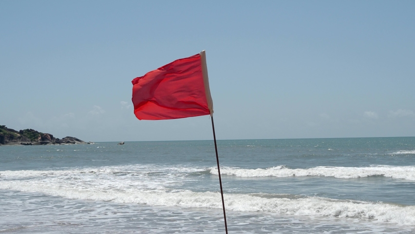 
Red flag as warning sign on the beach before storm means no swimming,  during windy sunny day Royalty-Free Stock Footage #1095025767