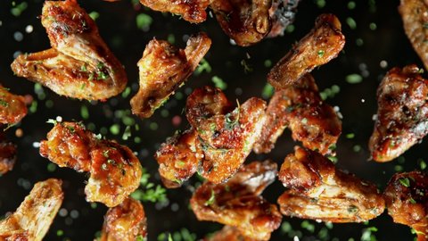 Super Slow Motion Shot of Grilled Spicy Chicken Wings Flying Towards Camera at 1000fps. Adlı Stok Video