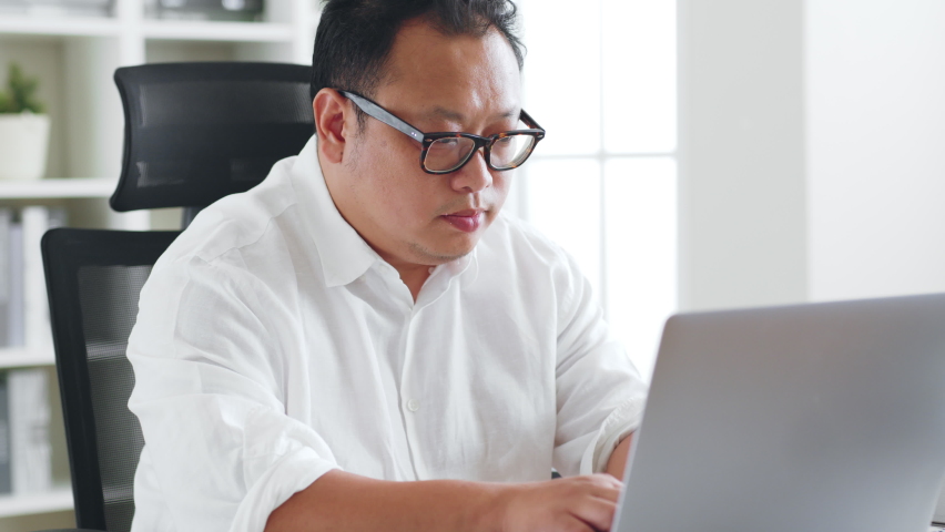 Middle-aged Asian man clutch his chest because heart attack symptom during working Royalty-Free Stock Footage #1095033053