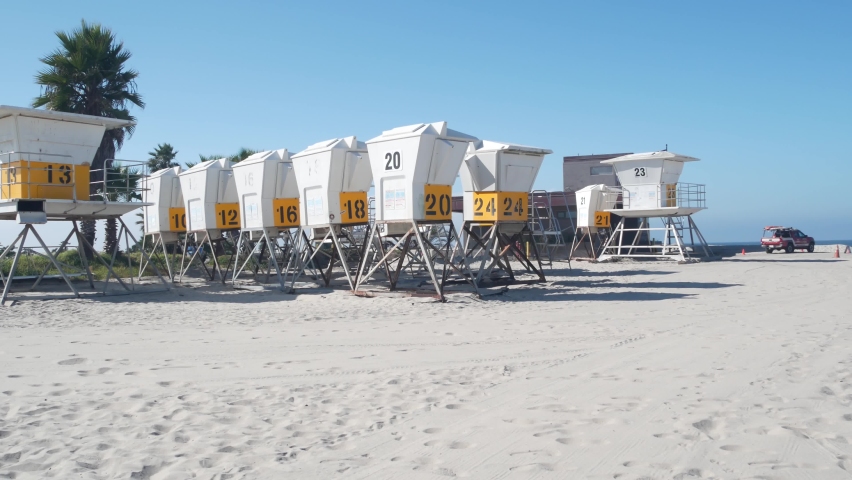 Lifeguard stand and palm tree, life guard tower for surfing on California beach. Summer pacific ocean in USA aesthetic. Iconic rescue baywatch station, coast lifesavers wachtower hut or house by sea.