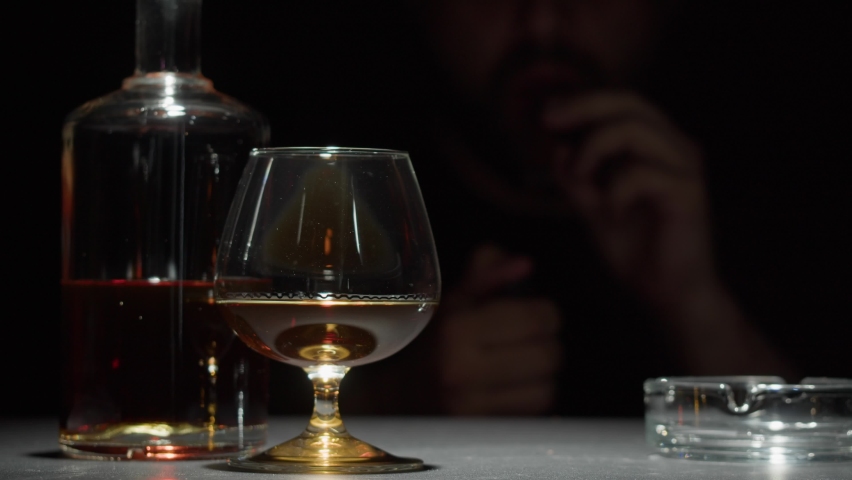 Brandy or whiskey and cigar close-up. Rich man smoking cigarette. Luxury cognac on black background. Alcohol amber drink, drinking rum, liqour beverage in glass. Royalty-Free Stock Footage #1095039671