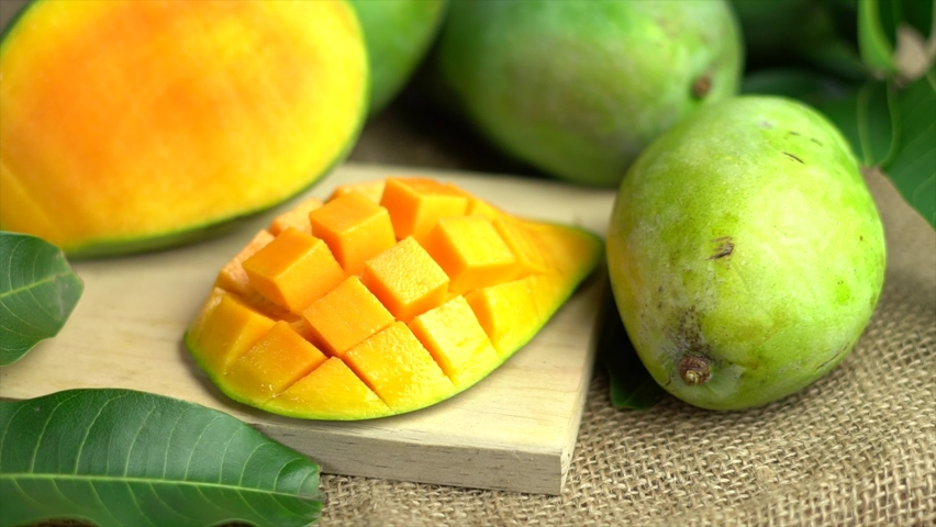 Mango fruit with mango slices. Isolated on the wooden table. Royalty-Free Stock Footage #1095049769