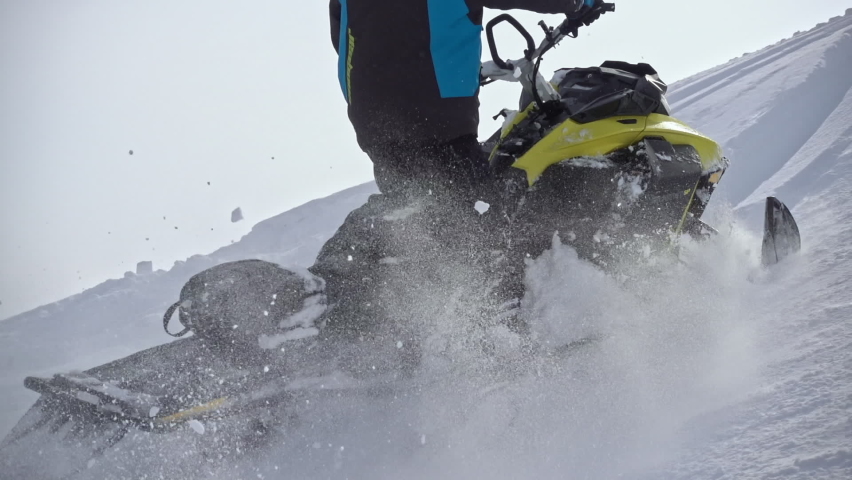 riding a mountain snowmobile with swirls of snow. snowmobiler. enchanting. for advertising winter outdoor activities and travel. 500FPS PRORES 422. slow motion. isolated on white snow background