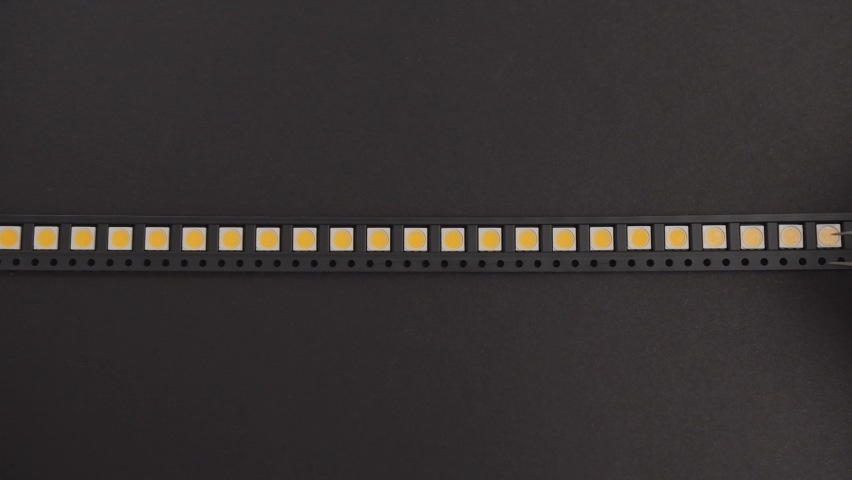 Manually Picking LEDs with Tweezers from a Black Strip - Powered by Shutterstock - Get 15% off with code: PIKWIZARD15