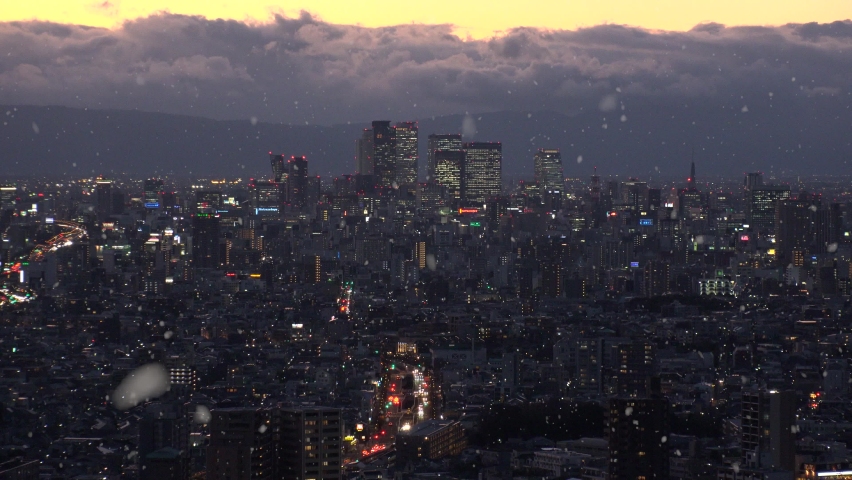 NAGOYA, JAPAN : Aerial high angle view of cityscape of Nagoya and falling snow. View of buildings around Nagoya station. Japanese winter and romantic Christmas season concept. Sunset or sunrise shot.