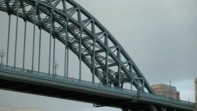 Close shot of Tyne Bridge as woman with umbrella walks across.