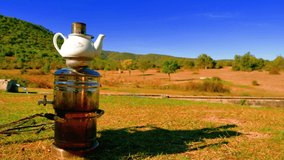 With samovar brewing tea in nature. camping chair beautiful view. Relaxing environment. beautiful nature. loneliness 4K video