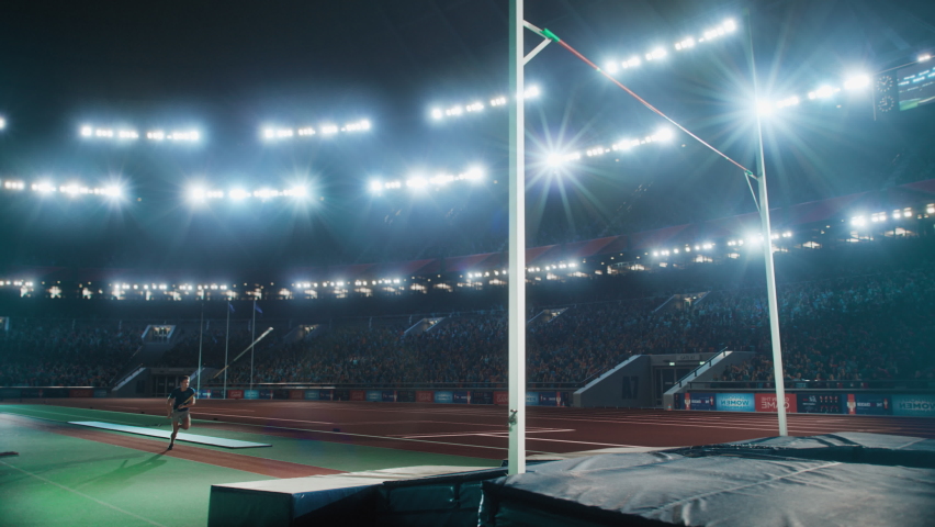 Pole Vault Jumping Championship: Professional Male Athlete Running with Pole Successfully Jumping over Bar and Landing on His Feet, Celebrates Record Setting Victory with Stadium Crowd Cheering Royalty-Free Stock Footage #1095065077