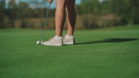 While playing golf, a girl hits the ball with a club and it hits the hole - Powered by Shutterstock - Get 15% off with code: PIKWIZARD15