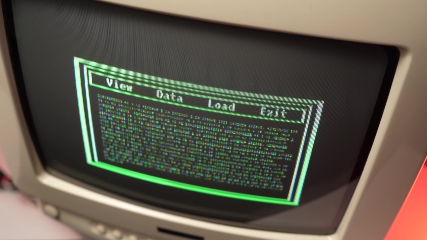 Vintage 80s 90s computer screen with green code hacking animation on the display. Retro computing concept.