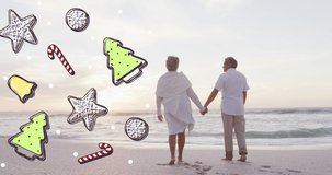 Animation of christmas icons over senior biracial couple at beach. Christmas, tradition and celebration concept digitally generated video.