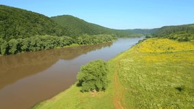 Grand river flows through the splendid valley and green forests. Footage from a bird's eye view. Location place Dniester canyon, Ukraine, Europe. Cinematic shot. Filmed UHD 4k video. Beauty of earth.