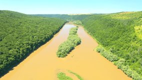 Grand river flows through the splendid valley and green forests. Footage from a bird's eye view. Location place Dniester canyon, Ukraine, Europe. Cinematic shot. Filmed UHD 4k video. Beauty of earth.