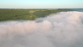 Flying over the fluffy clouds. Soft white clouds moving slowly in the valley. Footage from a bird's eye view. Cinematic shot. Dniester canyon, Ukraine, Europe. Filmed UHD 4k video. Beauty of earth.