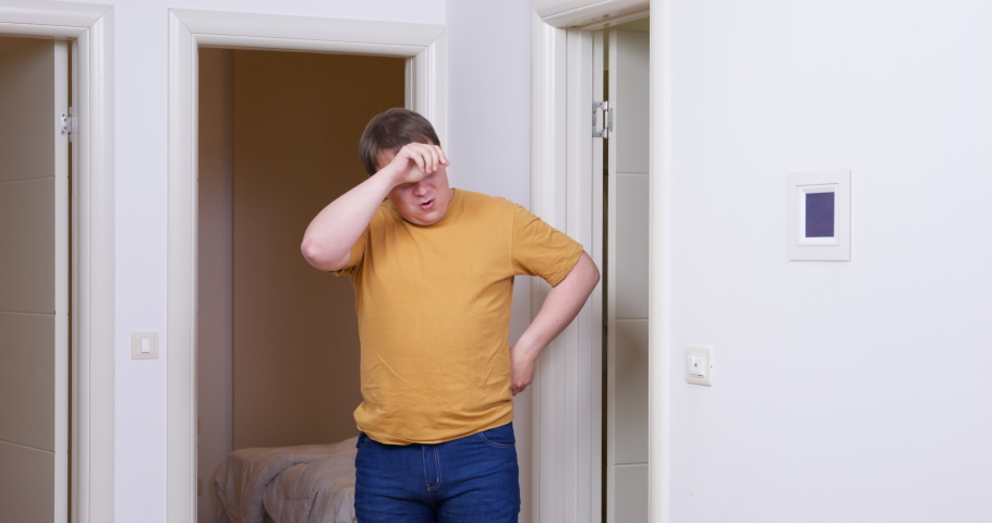Man with joy and relief wipes sweat from forehead, thinking that he has done job, but he looks around room dumbfounded, realizing that there is still a lot of work and his hands are hopelessly down