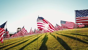 View on American USA flags waving in the wind against sunset in nature outdoor. Concept of 4th of July, Memorial Day, Independence Day, September 09,11,2001. Back light. High quality 4k footage - Powered by Shutterstock - Get 15% off with code: PIKWIZARD15