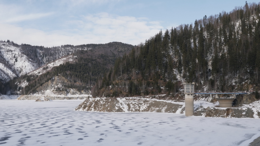 4K. Beautiful winter landscape with a snowy lake surrounded by snowy mountains. Slow motion